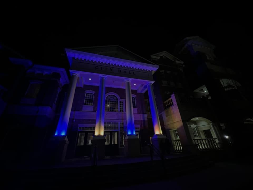 Photo of Duluth City Hall with yellow and blue lights.